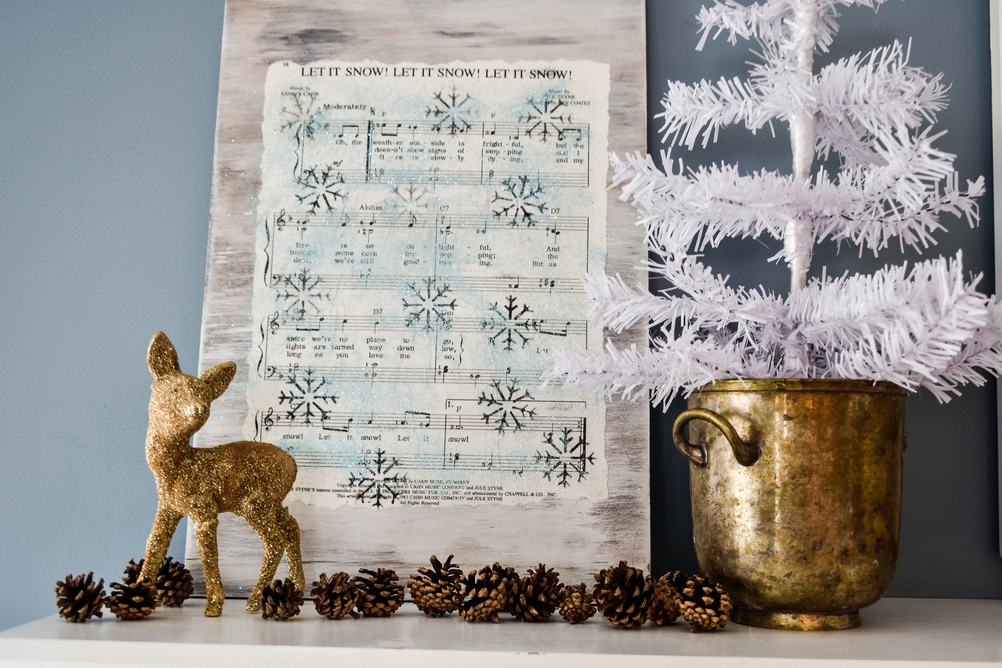 Christmas mantel with a stenciled music sheet decoration.
